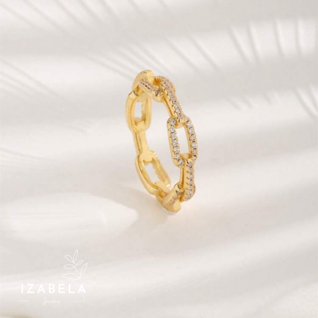 Gold ring with diamond accents on a white background, featuring the brand 'IZABELA'.