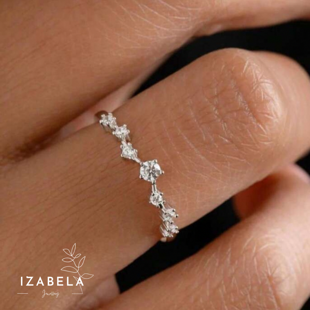 Silver ring with diamonds on a finger, brand 'IZABELA' visible